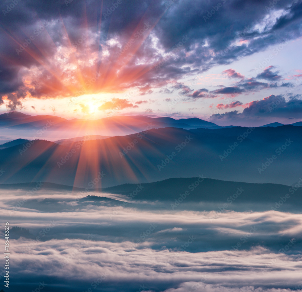 Magical and colorful landscape in the mountains at sunrise. View of foggy hills covered by forest.