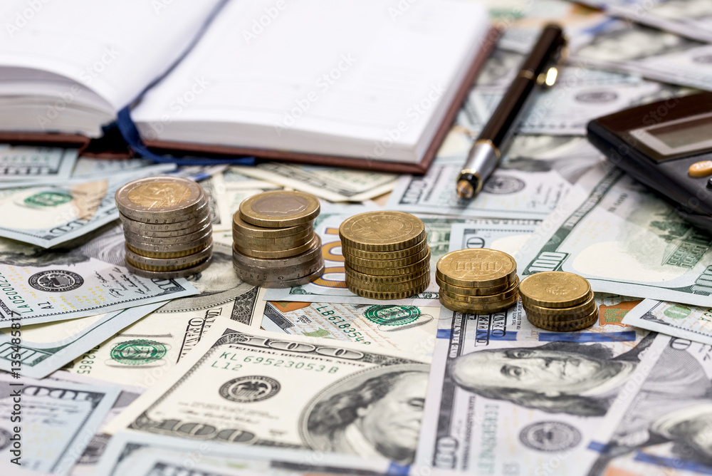 Fototapeta premium dollar bills with coin and calculator. close up.