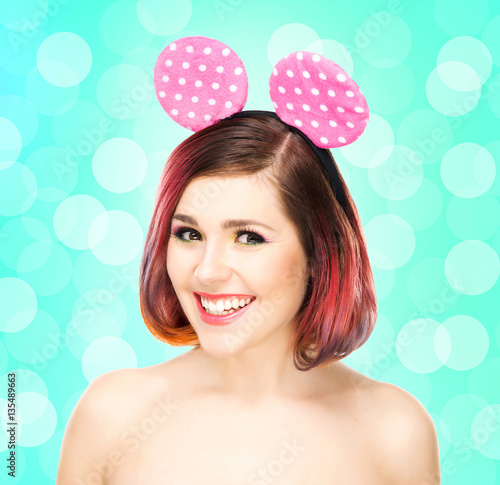 Beautiful young smiling woman in mickey mouse ears on bubble background.