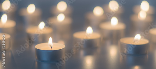 Flame of many candles burning on the background blue color