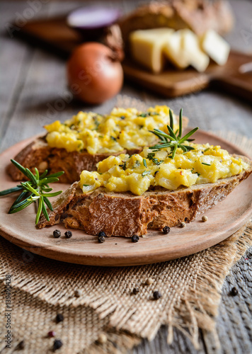 Whole meal bread slices with scrambled eggs, cheese and onion