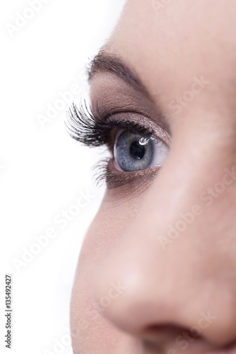 Fototapeta Naklejka Na Ścianę i Meble -  Close up of human female eye and nose on white