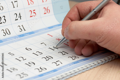 Hand marks date in the calendar