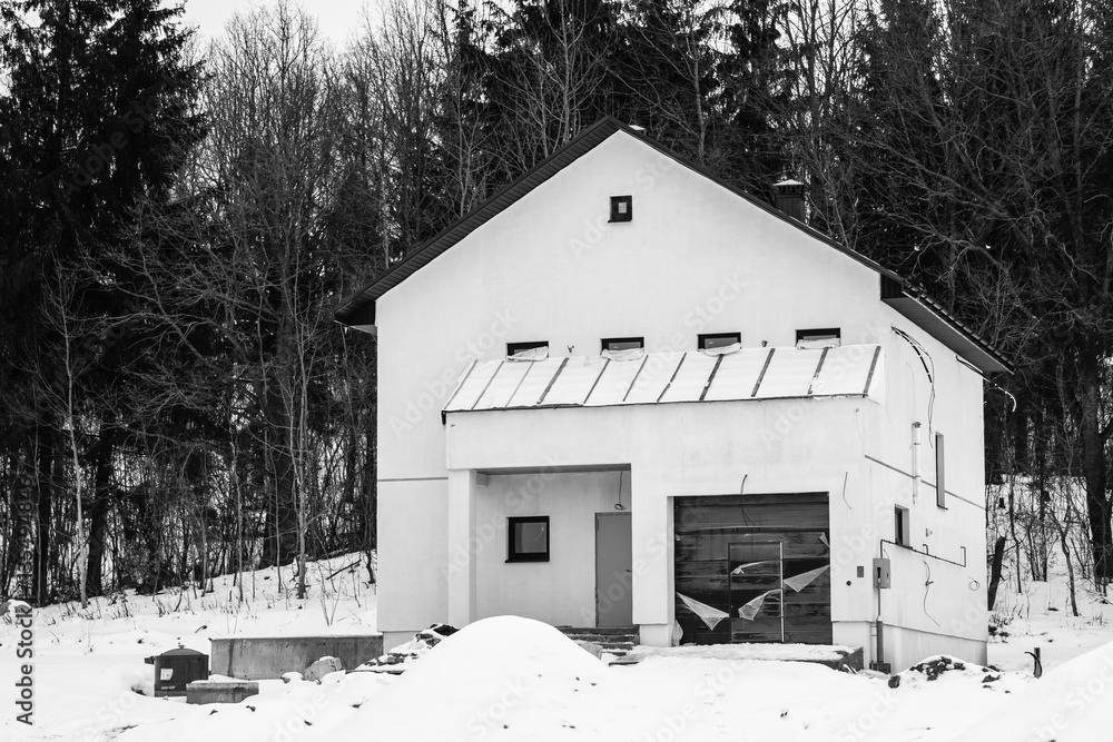 Naklejka premium Under construction house of foam blocks. Cottage settlement. Suburb. Private construction. Unfinished city. Winter. Snow. Overcast.
