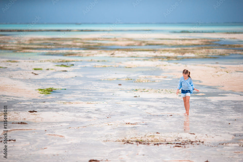 Adorable little girl on the beach in low tide in Zanzibar