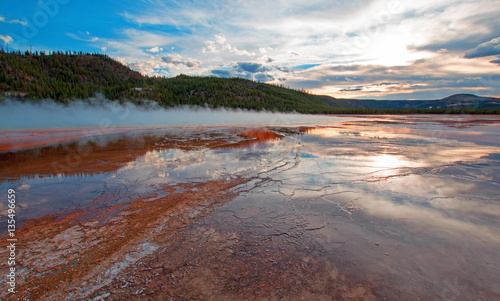 Fototapeta Naklejka Na Ścianę i Meble -  Grand Prismatic Spring under sunset cloudscape in the Midway Geyser Basin in Yellowstone National Park in Wyoming USA