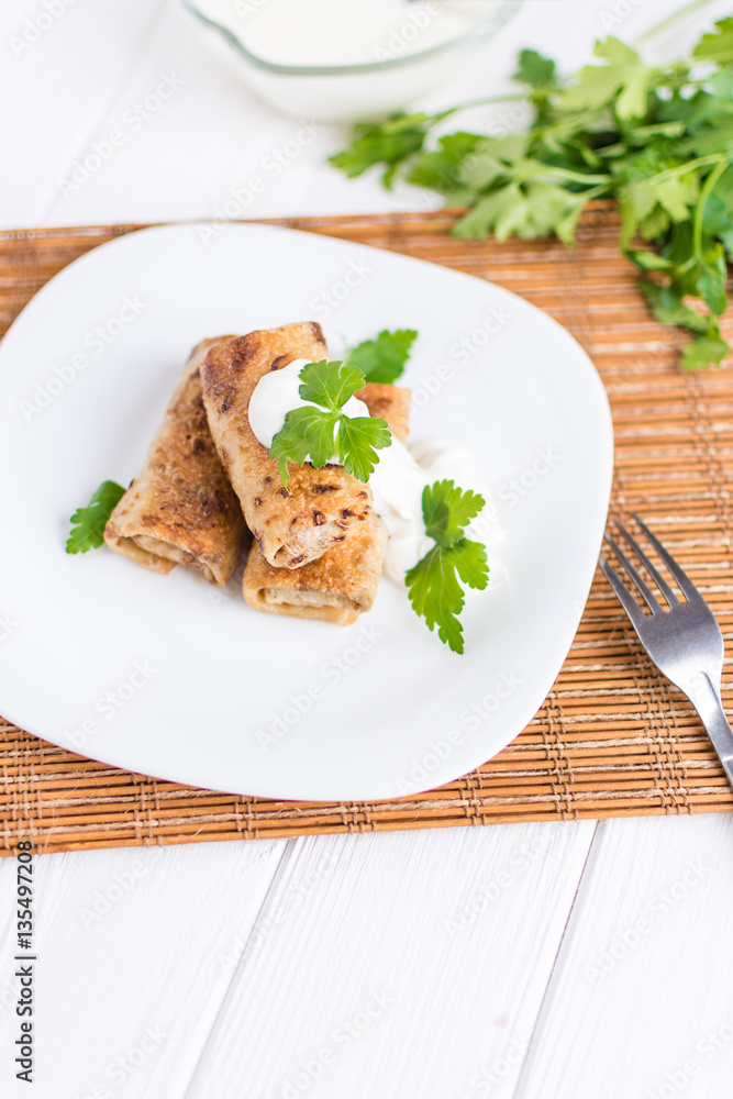 Pancakes filled with meat stuffing on a white plate Pancakes filled with meat stuffing on a white plate
