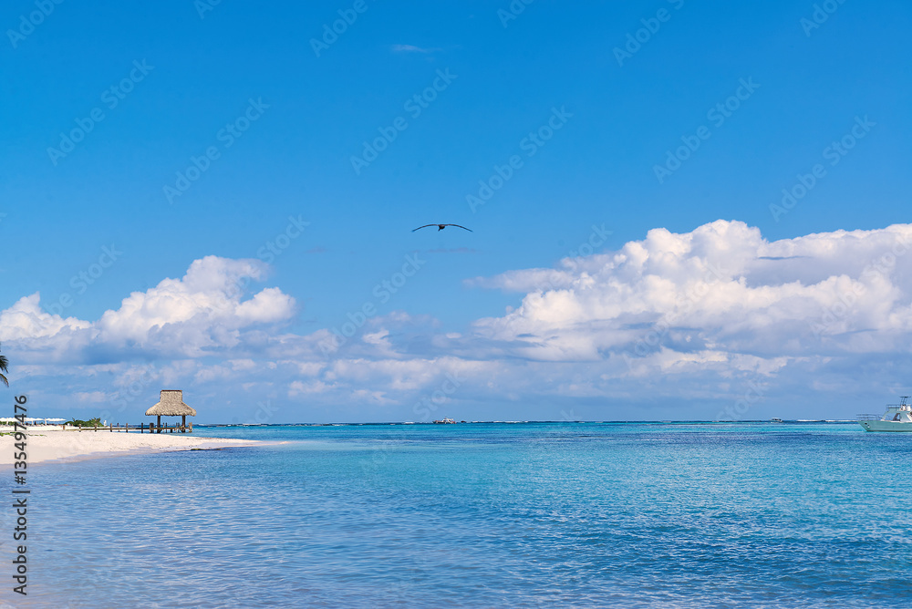 Fototapeta premium Tropical white sandy beach. Palm leaf roofed wooden pier with ga