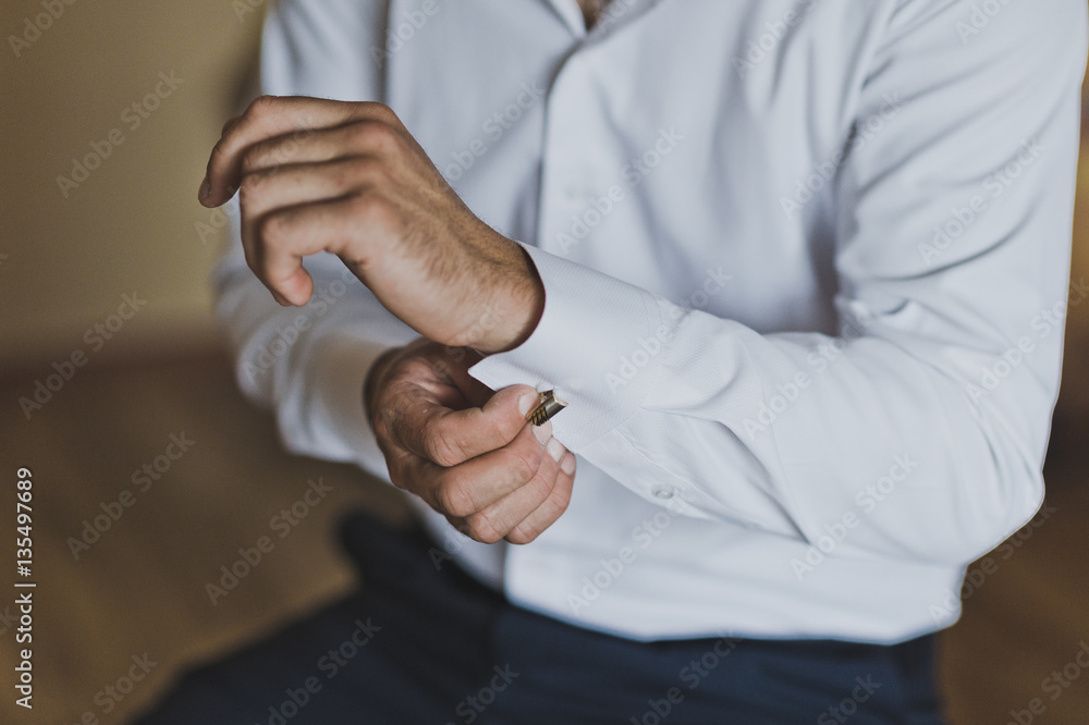 Fototapeta premium Young man buttoning the cuff links on the sleeves 7441.