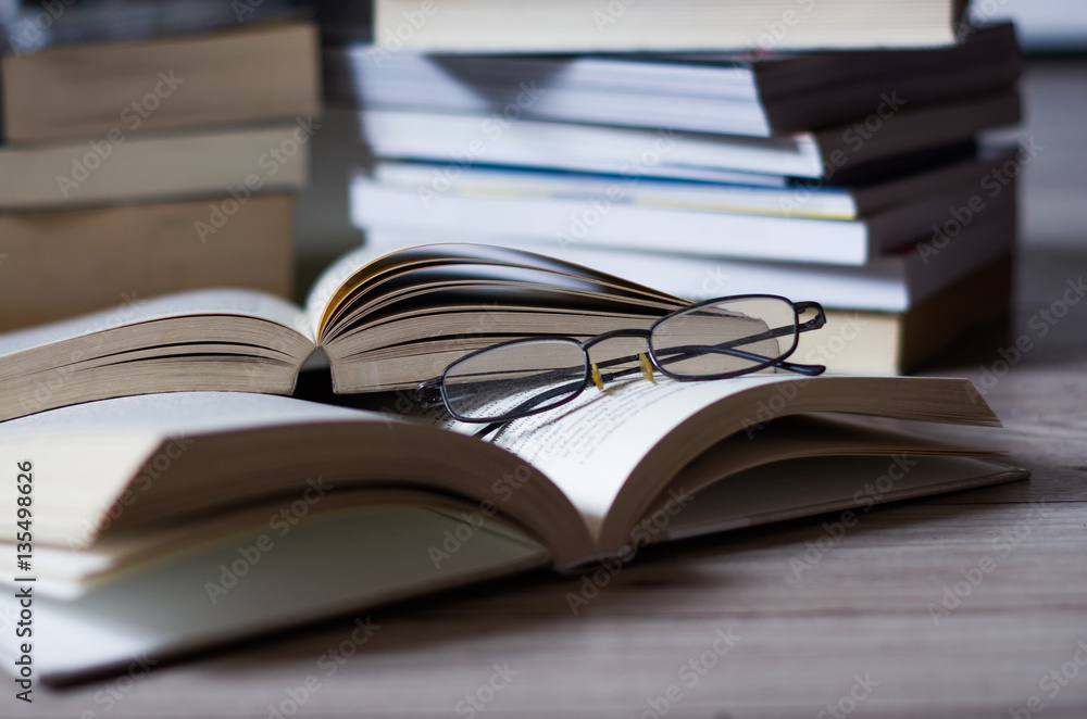 Open book on the table, glasses. Open book on the table, glasses.