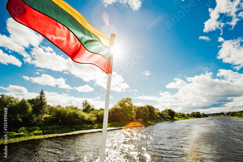 Lithuanian flag on boat while traveling by the river photo