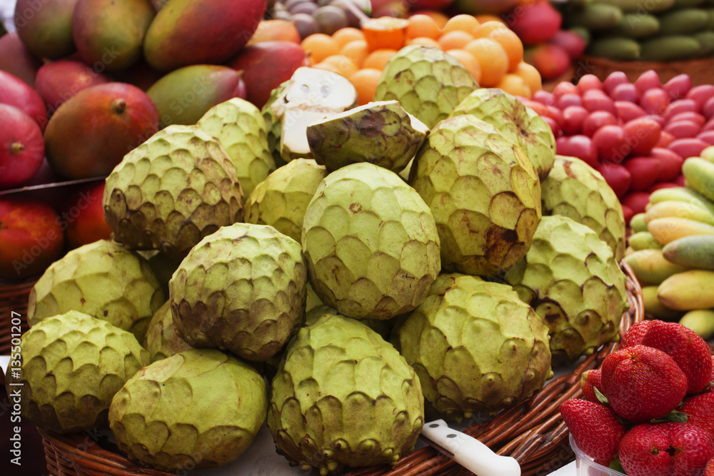 Fototapeta premium Annona fruit and variety of exotic fruit on a street market. Funchal, Madeira, Portugal.