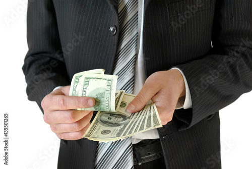Man in black business suit, holding cash in hands.