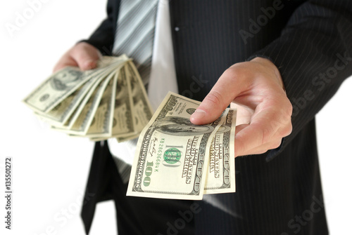 Man in black business suit, holding cash in hands.