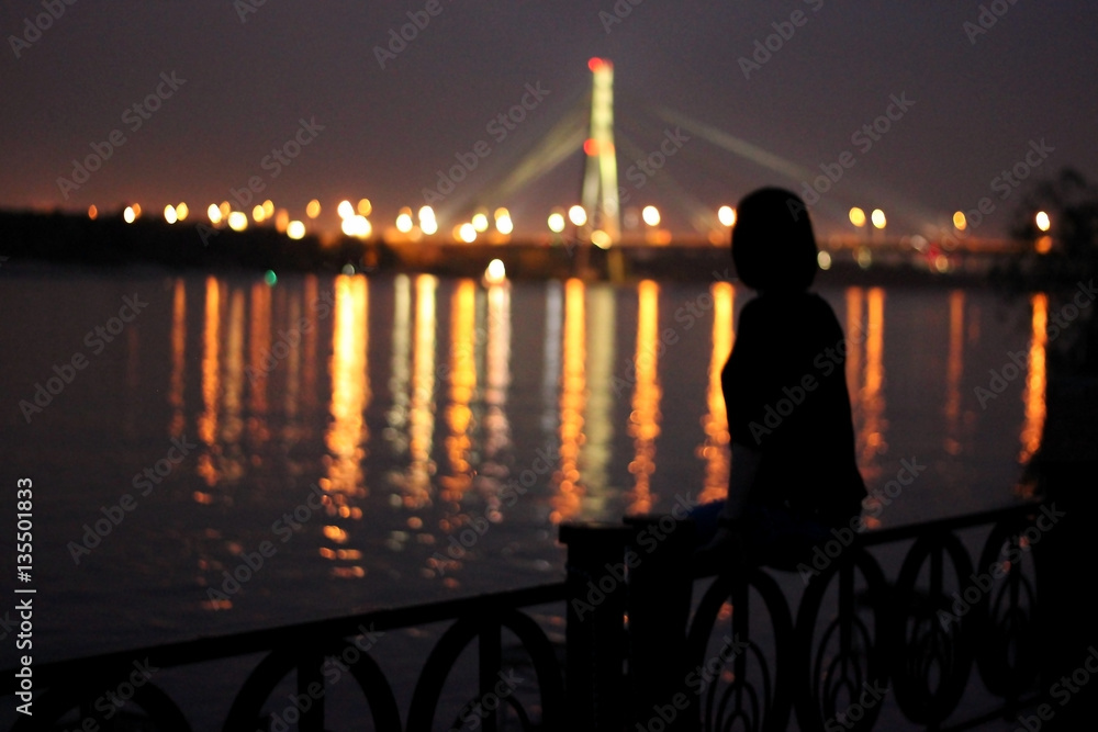 Woman watching a beautiful night bridge