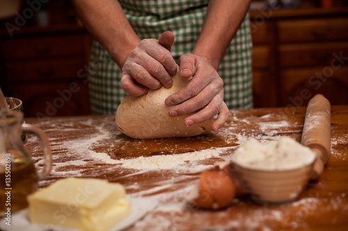 Senior man hands knead dough on table ,home kitchen