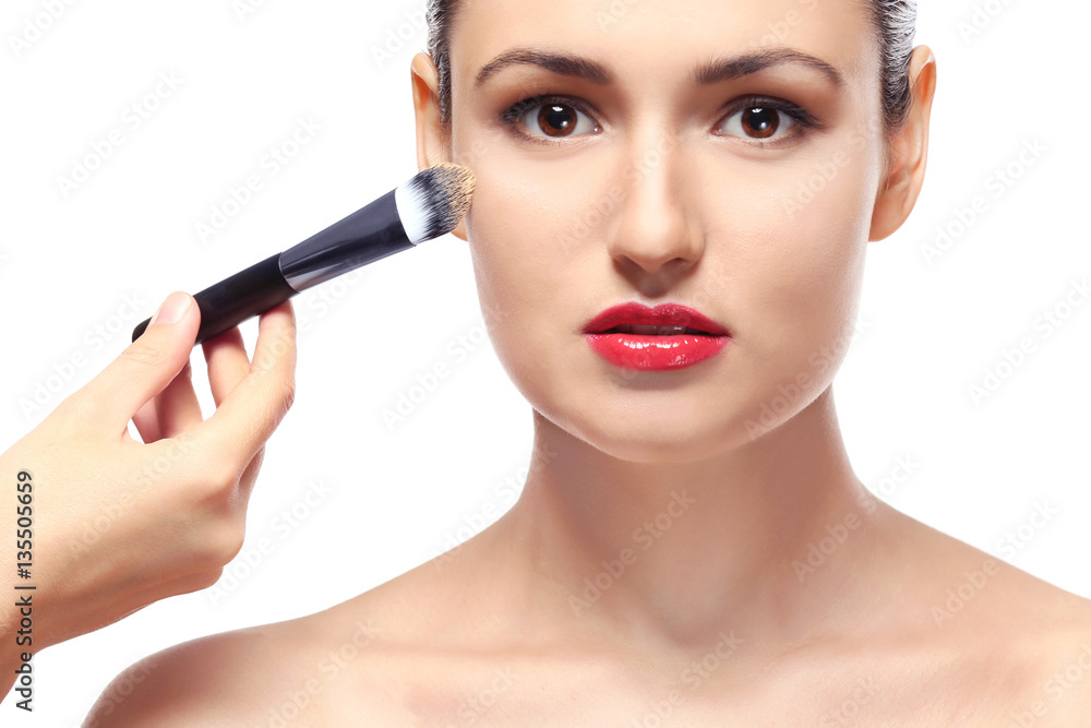 Beautiful girl applying cosmetics on white background Beautiful girl applying cosmetics on white background
