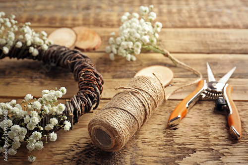 Beautiful floral wreath with tools for hand-made on wooden background