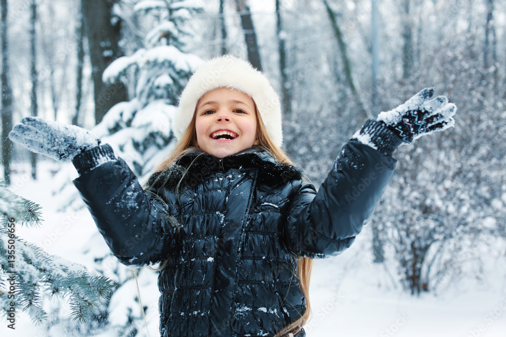 Cute little girl playing with snow in winter park Cute little girl playing with snow in winter park