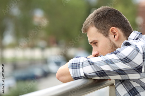 Sad man looking down from a balcony