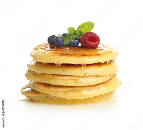 Delicious pancakes with berries and sweet syrup on white background