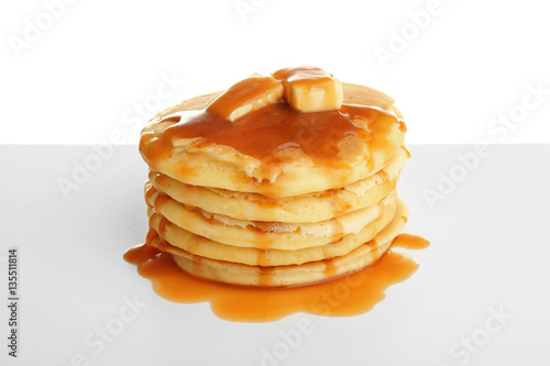 Tasty pancakes with caramel syrup isolated on white