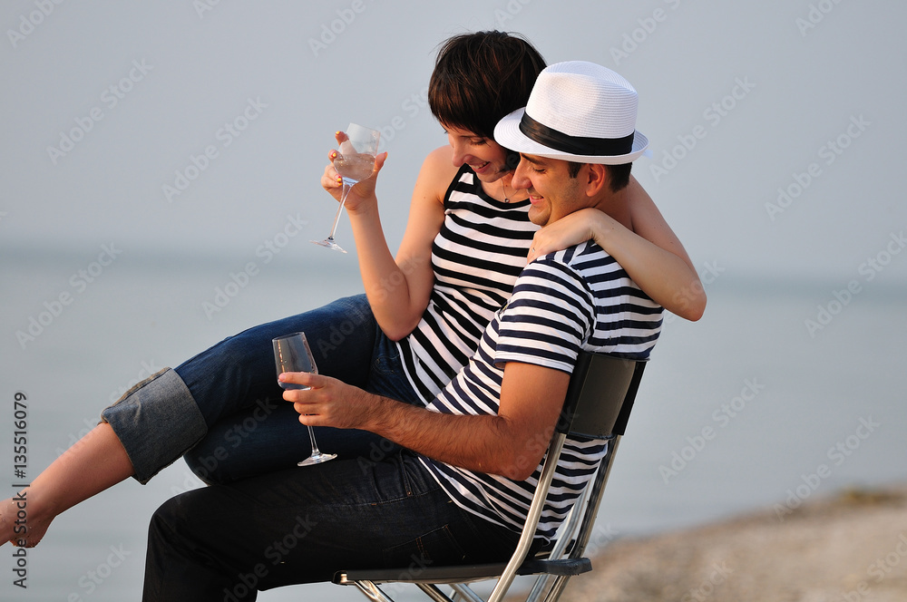 Fototapeta premium couple sitting on beach with wine