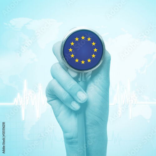 hand holding stethoscope with European Union flag.