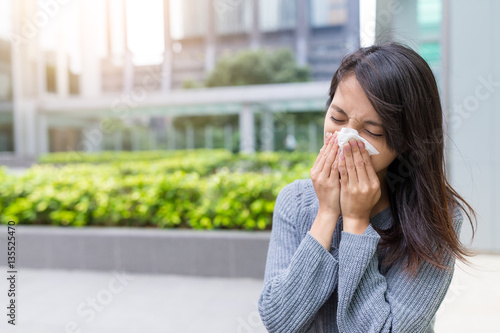 Asian Woman sneezing at outdoor