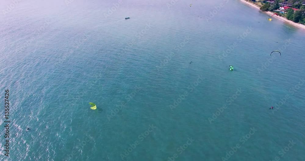 Aerial view of kitesurfer gliding across blue ocean, extreme sport drone footage 4K Aerial view of kitesurfer gliding across blue ocean, extreme sport drone footage 4K