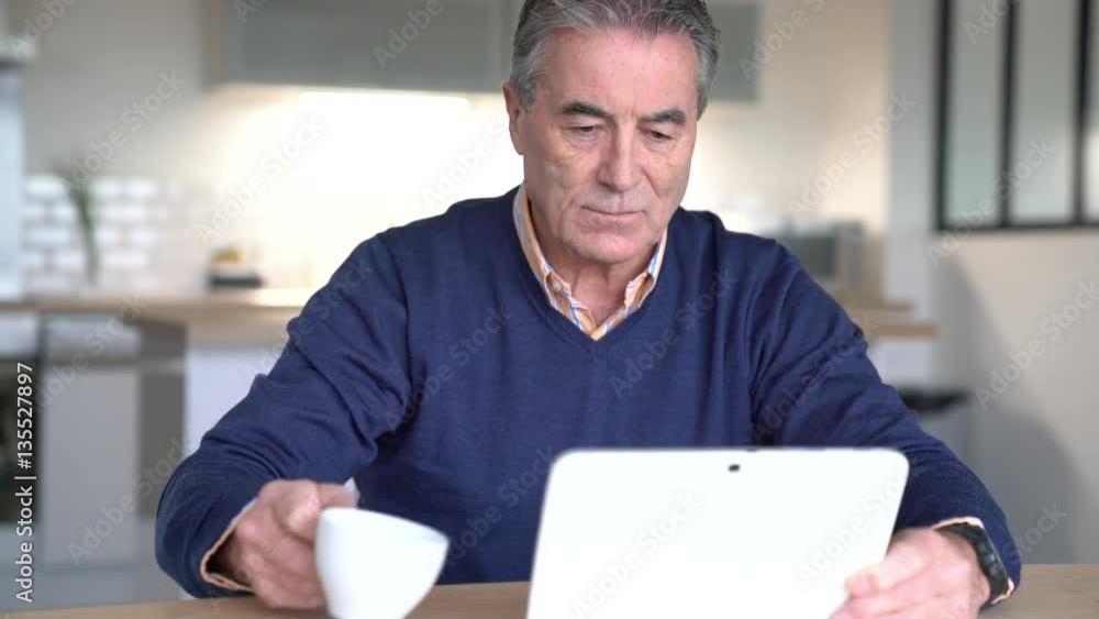 Senior man drinking coffee and using digital tablet Senior man drinking coffee and using digital tablet