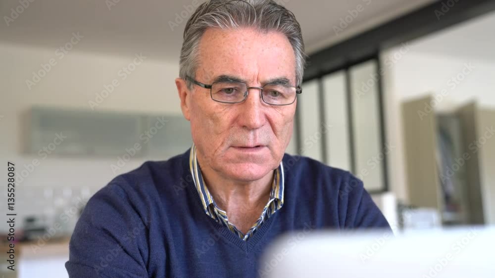 Senior man with eyeglasses using laptop computer Senior man with eyeglasses using laptop computer