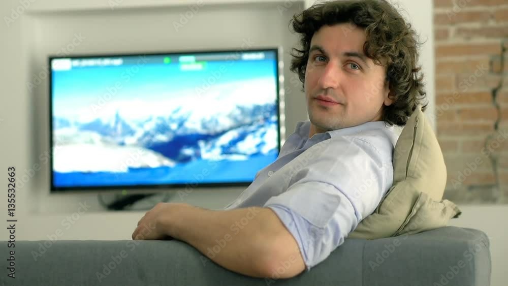 Man relaxing on the sofa and looking to the camera
Man relaxing on the sofa and looking to the camera