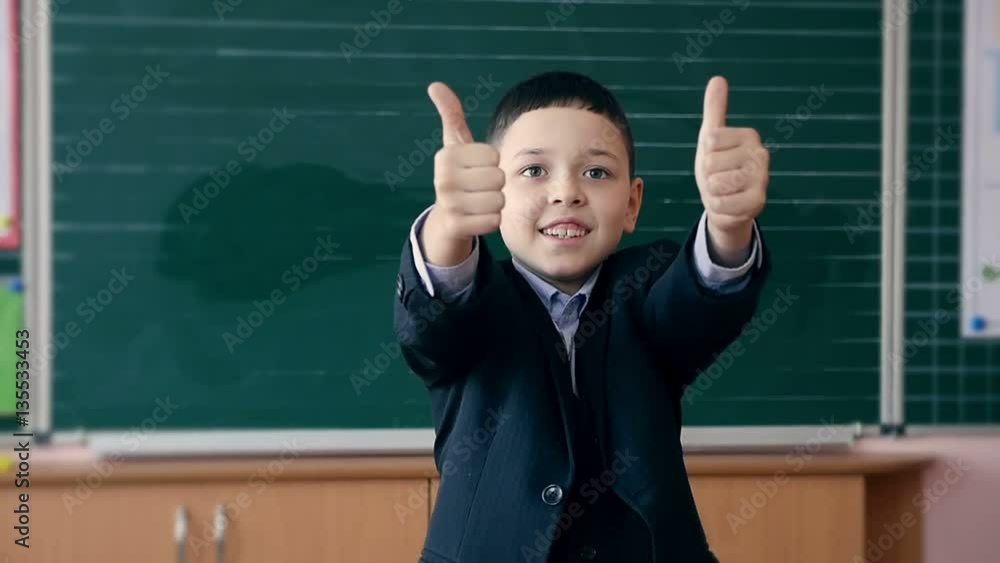 A smiling pupil showing two thumb up gesture in his class.Slow motion A smiling pupil showing two thumb up gesture in his class.Slow motion