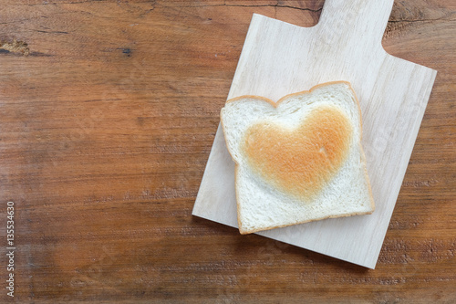 bread with heart shape burn on wooden table