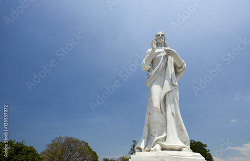 Grand stone white statue of Jesus in Havana at summer sunny day