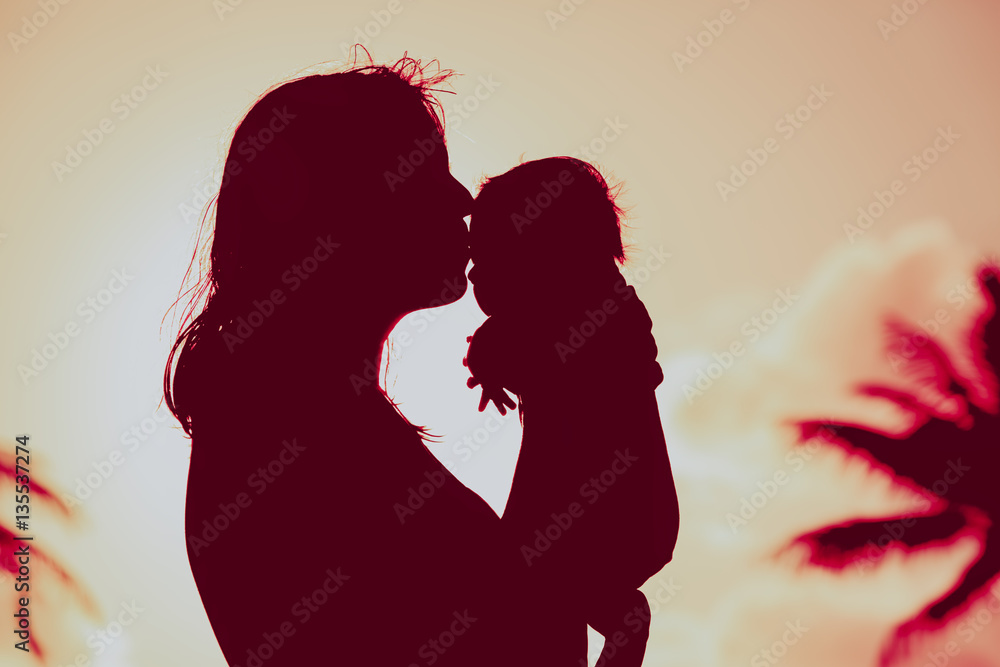 loving mother and kissing little baby play at sunset loving mother and kissing little baby play at sunset