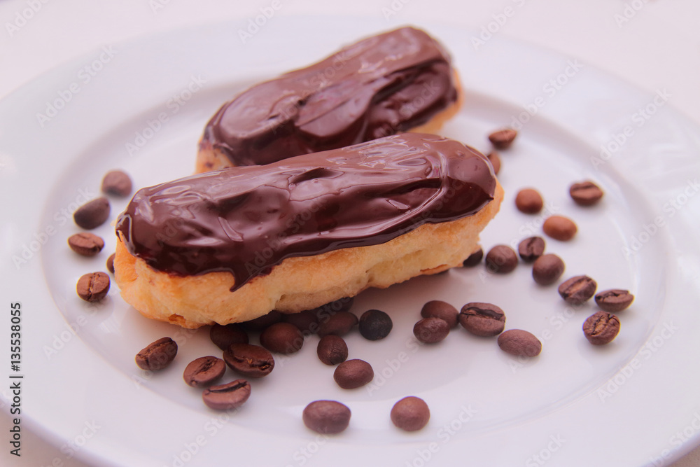 Chocolate eclairs on plate on white background Chocolate eclairs on plate on white background