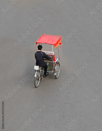 Unidentified cyclo rickshaw driver on a street in Hanoi capital, Vietnam.