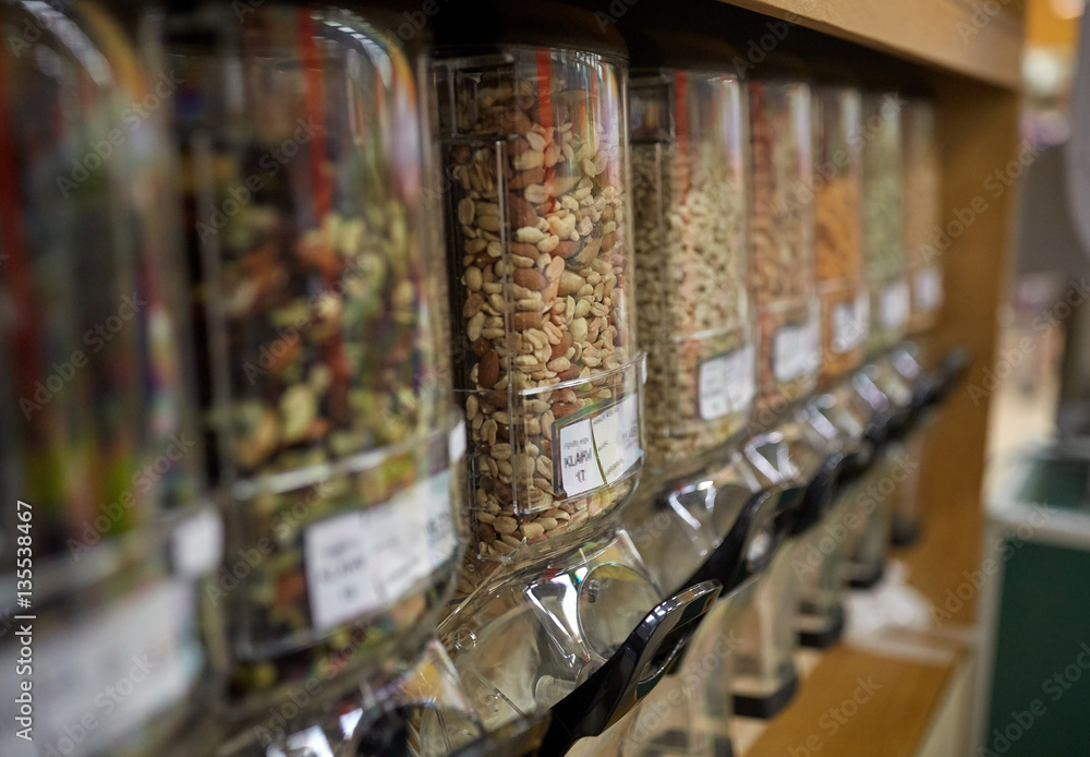 row of jars with nuts and seeds at grocery store