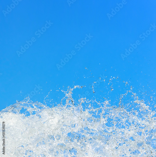 Water splashing on the background of blue sky