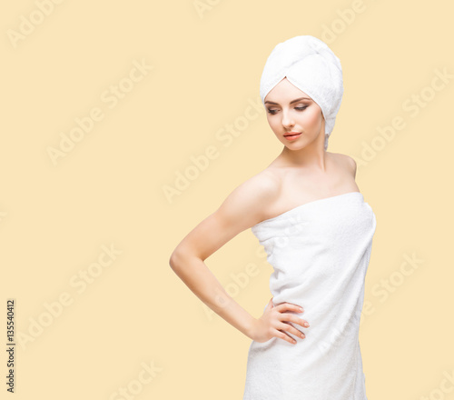 Young, beautiful and natural woman wrapped in towel isolated on