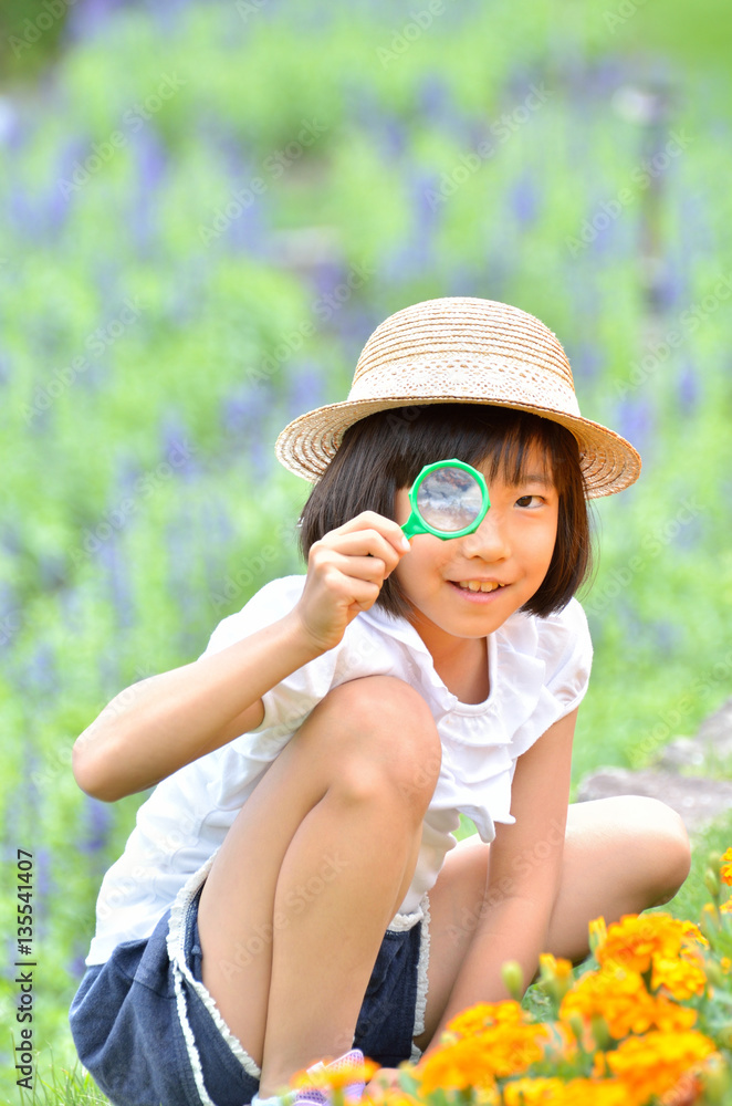 虫めがねで花を観察する女の子 麦わら帽子 Stock Photo Adobe Stock