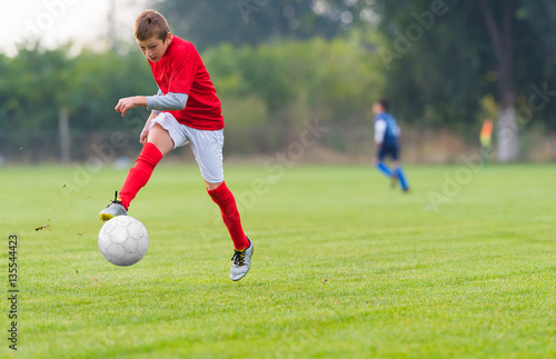 Boy kicking soccer ball © Dusan Kostic