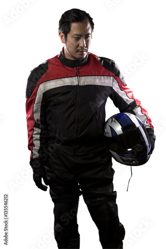 Man wearing a protective leather and textile racing suit for race cars and motorcycle motor sports.  The gear is armored with a helmet and worn by bikers and professional drivers.