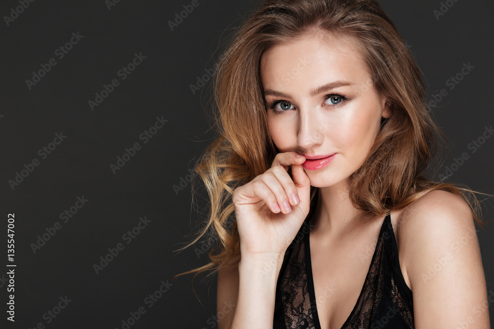 Pretty woman standing and posing over dark background. Pretty woman standing and posing over dark background.