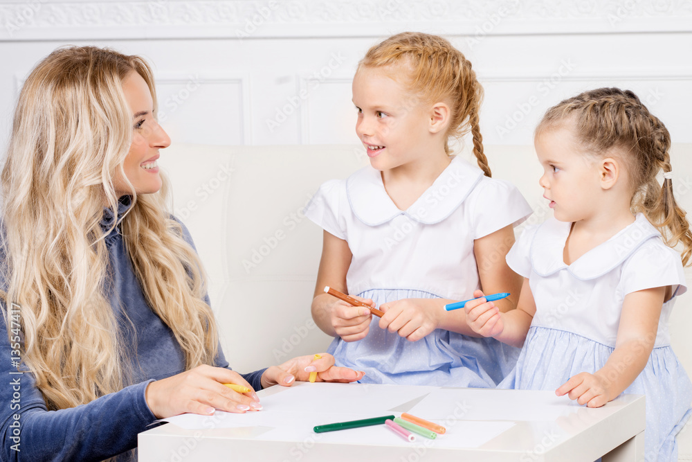 Mother with two beautiful daughters are drawing. Family, motherhood concept. Mother with two beautiful daughters are drawing. Family, motherhood concept.