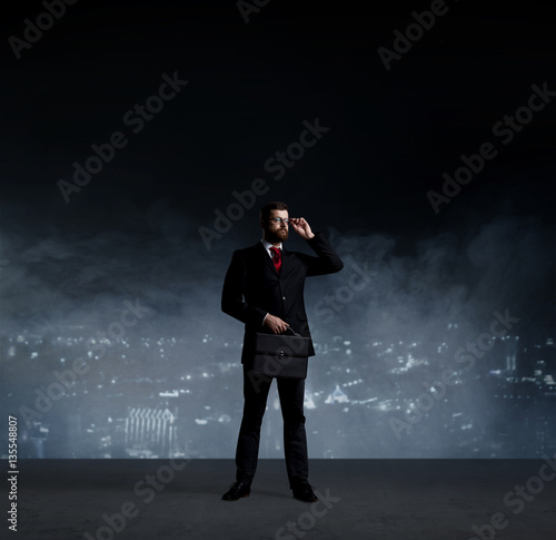 Businessman in suit and tie. Black background with copy space. B