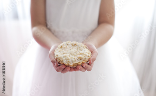 Dziewczynka z ciastkiem - ciastko - babeczka - pierwsza komunia - chlebek - ręce - dłonie