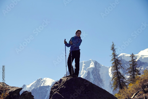 Brave girl conquering mountain peaks of the Altai mountains. The majestic nature of the mountain peaks and lakes. Hiking in rugged places. Journey through Russia, Siberia, Aktru and shavlinskoe lake photo